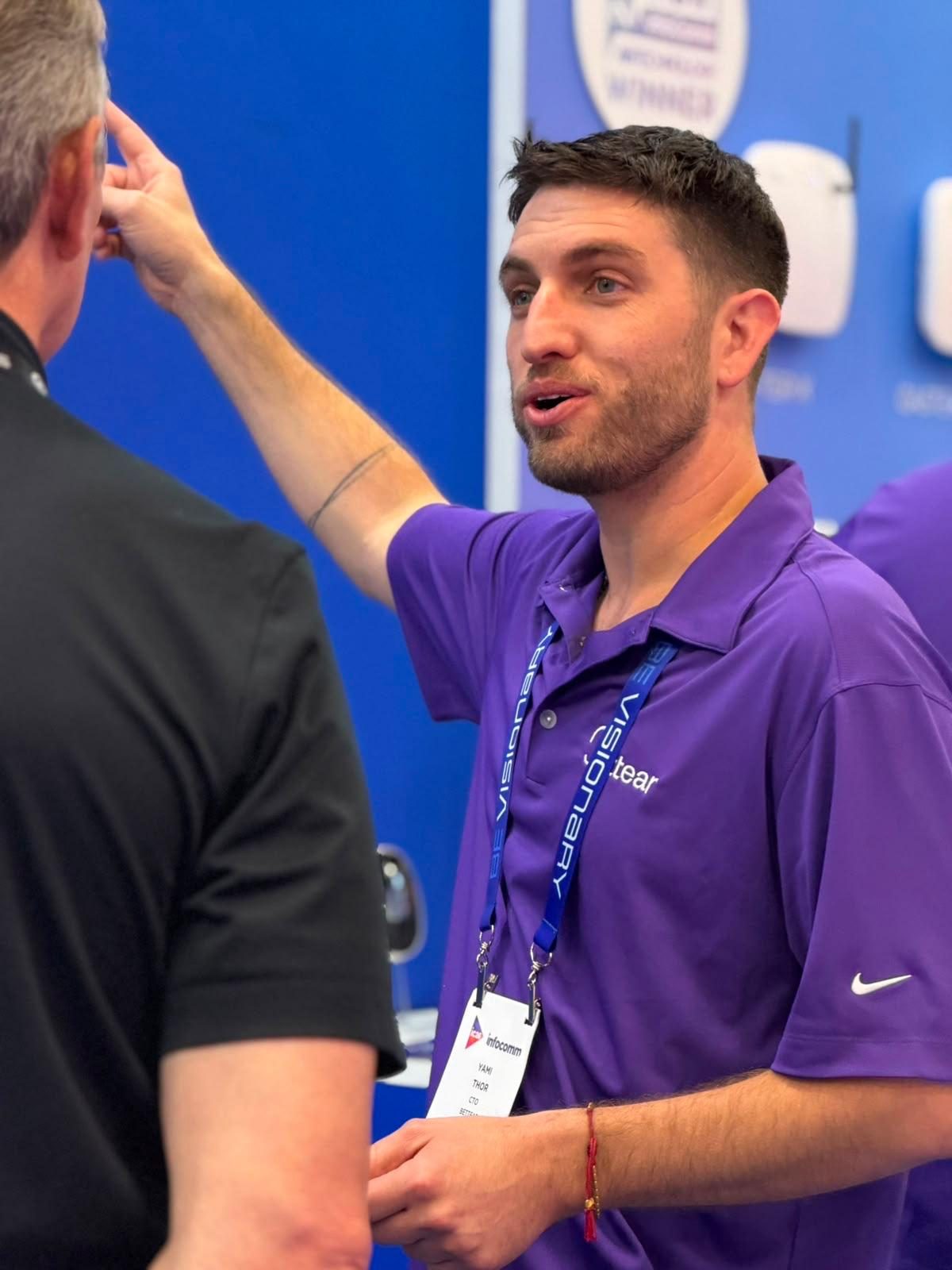 Fitting earbuds on a visitor at the Bettear booth