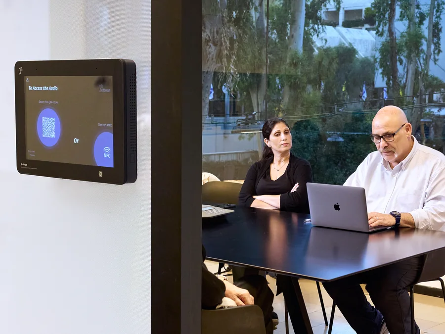 A meeting room with a B-PASS panel on the wall