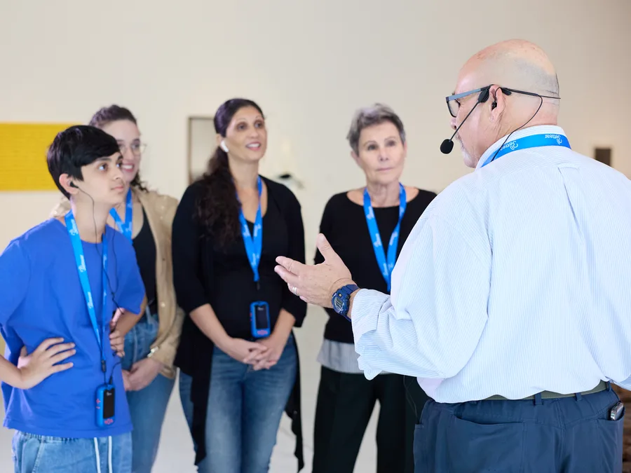 A museum guide with a headset microphone talking to his group, who listen on RTX receivers